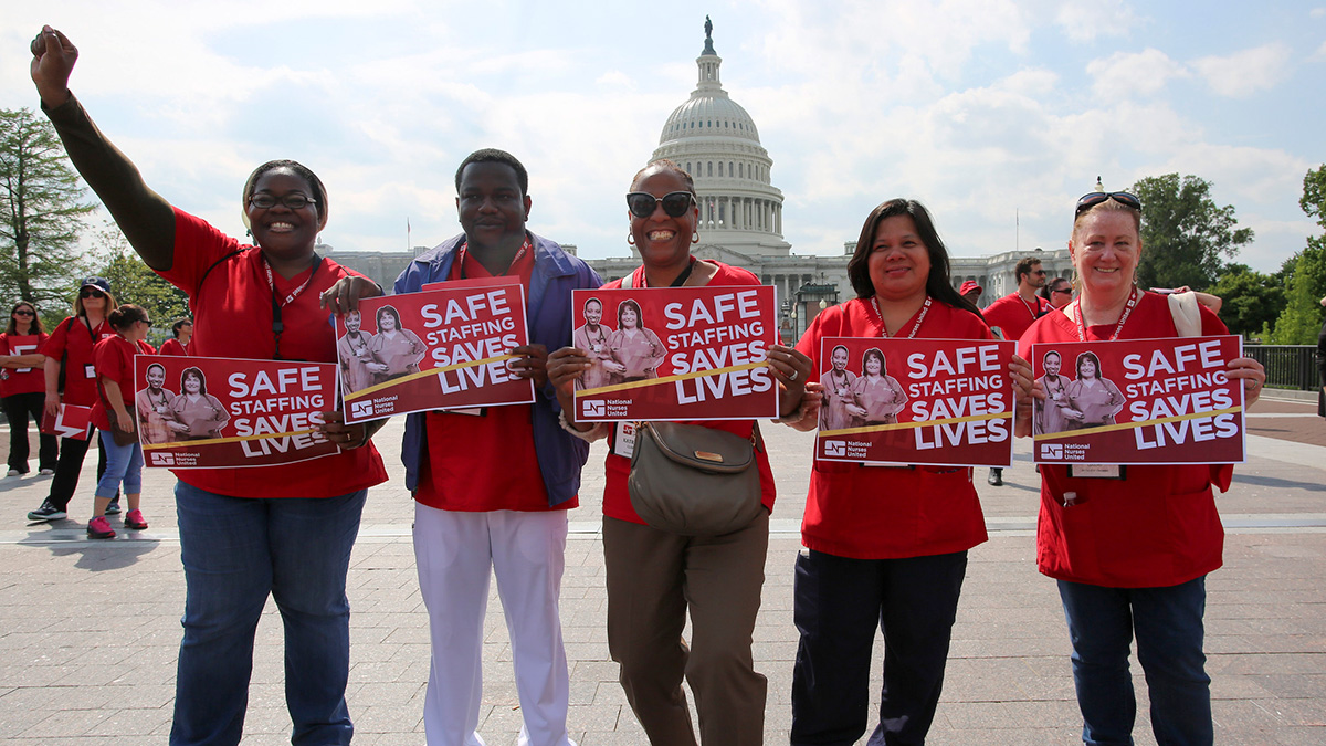 Five nurses outside U.S. Capitol Building hold signs "Safe Staffing Saves Lives"