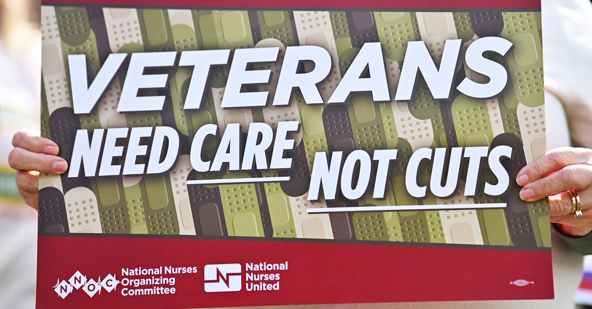 Nurse holding sign "Veterans need care not cuts"