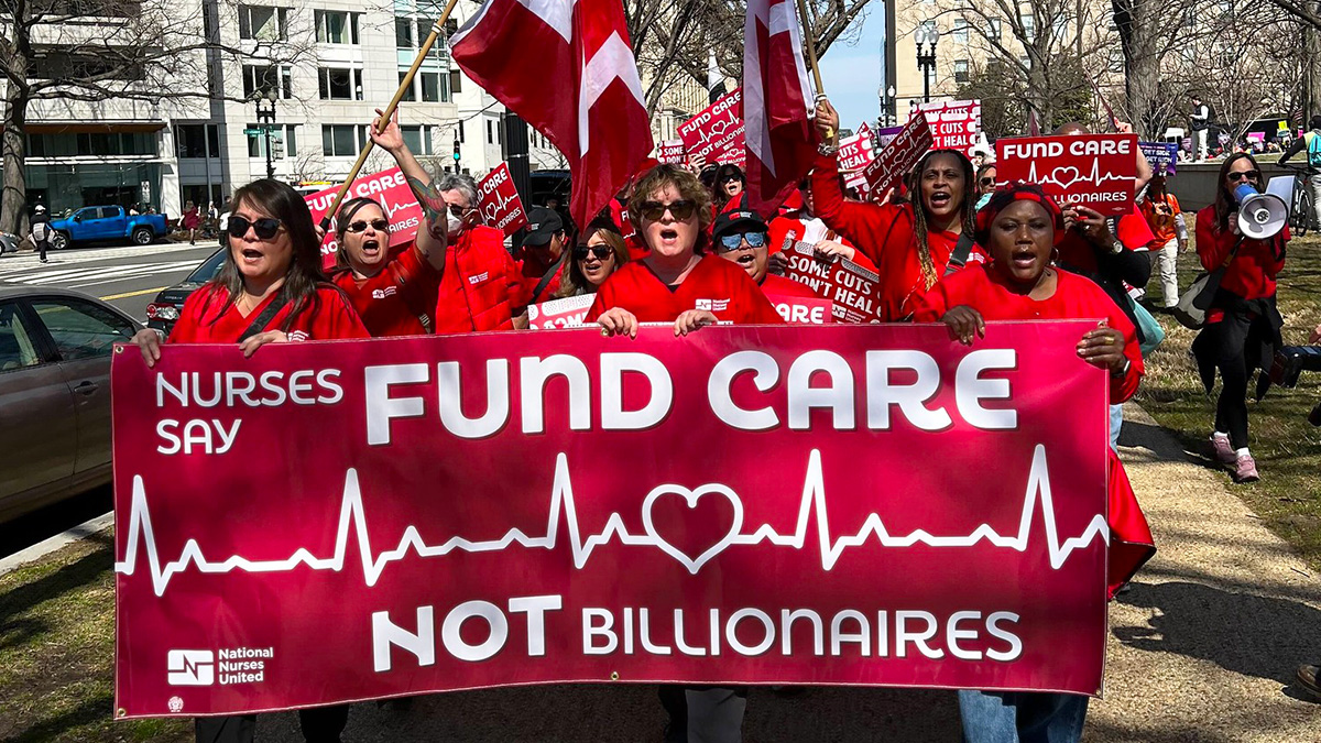 Nurses marching, holding banner "Fund Care NOT Billionaires"