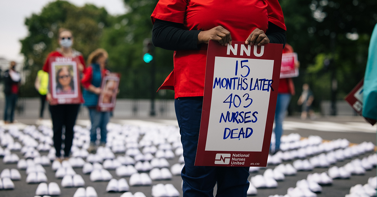 Nurse holds sign "15 months later, 403 nurses dead"