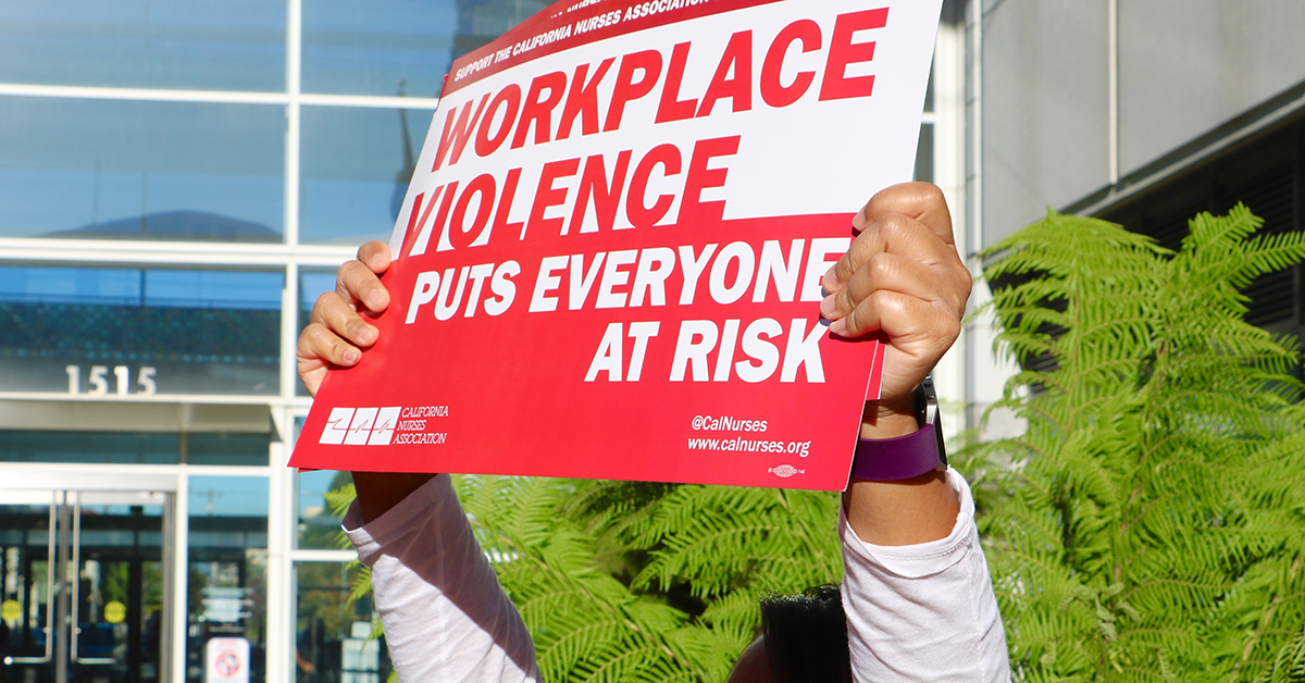 Nurse holding sign "Workplace Violence puts everyone at risk"