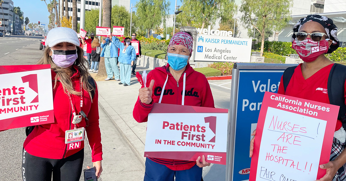 Group of three nurses outside LA Medical Center hold signs "Patients First"