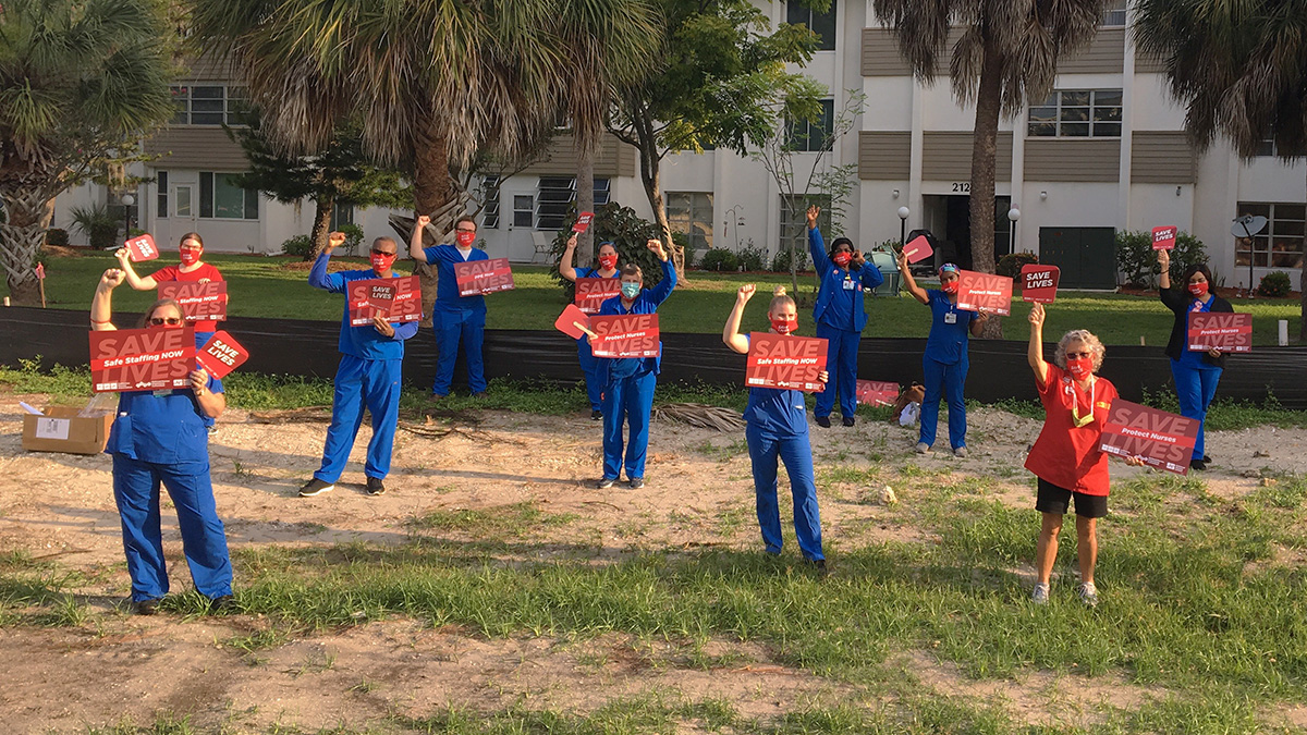 Group of nurses outside with raised fists