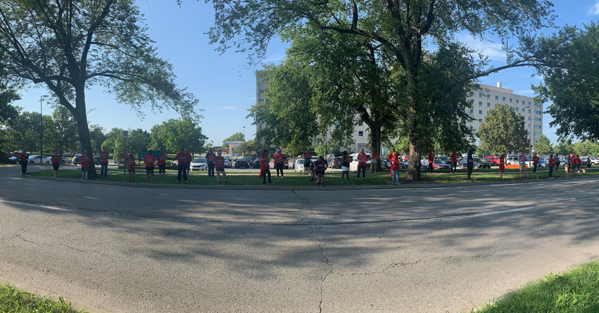 Wide shot of nurses protesting in front of hospital