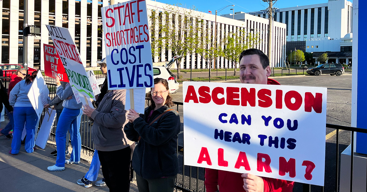Nurse holds signs "Ascension can you hear this alarm?"