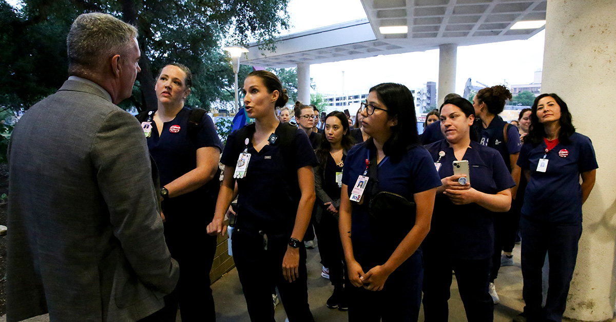 Nurse being confronted by management at entrance to hospital