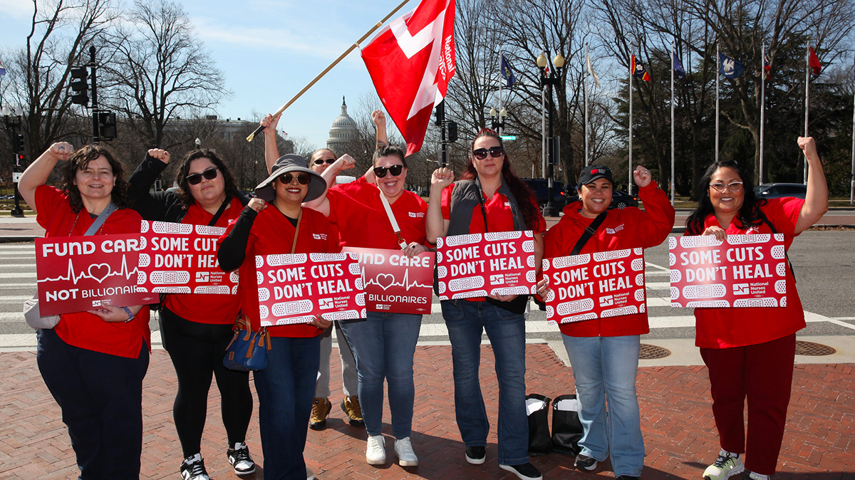 Large group of nurses outside Capitol building in Washington, D.C., holding signs "Fun Care, Not Billionaires" and "Some Cuts Don't Heal"