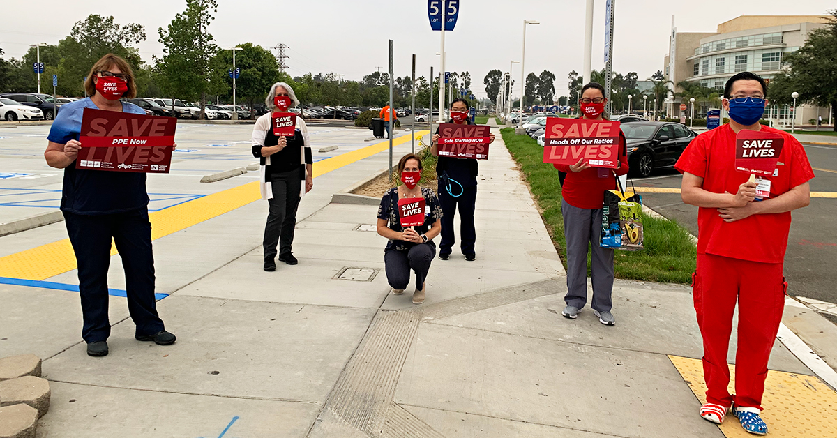 Nurses hold signs "Save Lives" and variations "Hands Off Our Ratios" "Safe Staffing Now" "PPE Now"