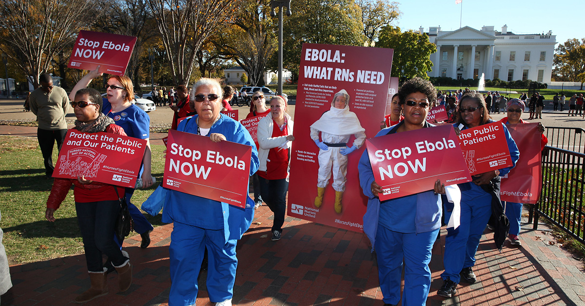 Nurse outside The Whitehouse holding signs "Stop Ebola Now"