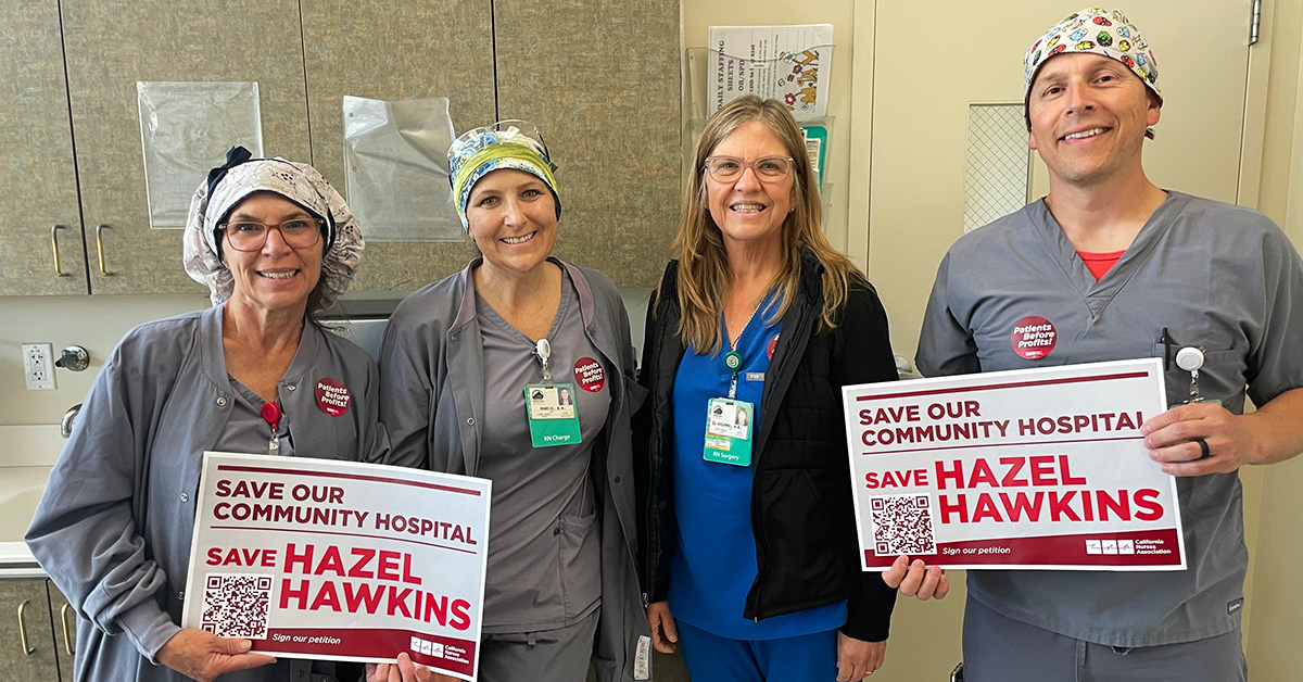 Four nurses hold signs "Save Our Community Hospital: Save Hazel Hawkins"