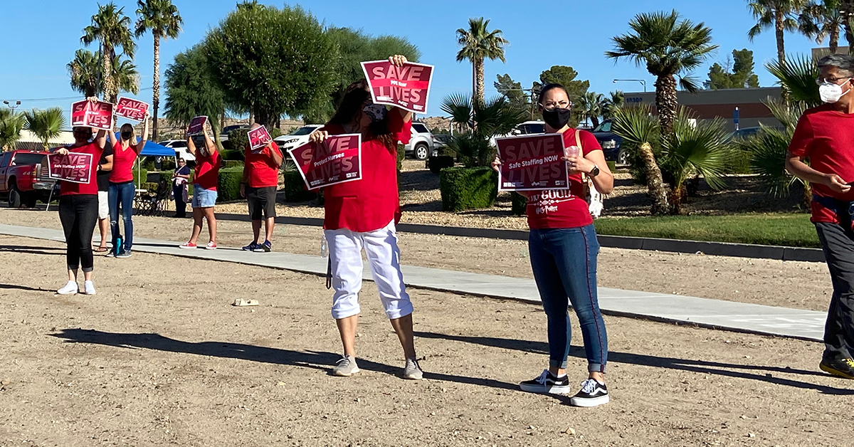 RNs holding signs, SAVE LIVES