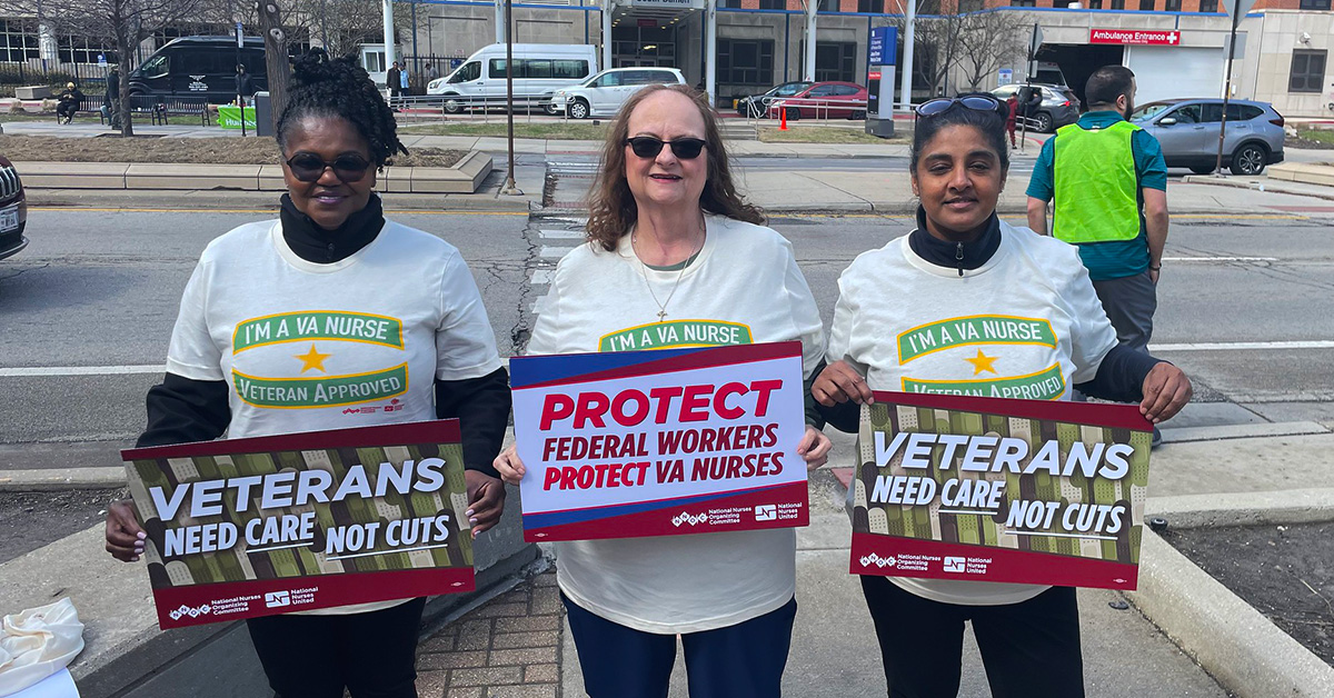 Three nurses outside hospital holding signs "Veterans Need Care Not Cuts" and "Protect Federal Workers"