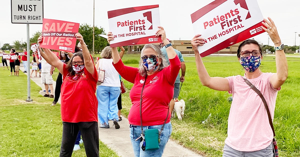 Nurses holding signs "Patients Firsts" and "Save Lives: Hands Off Our Ratios"