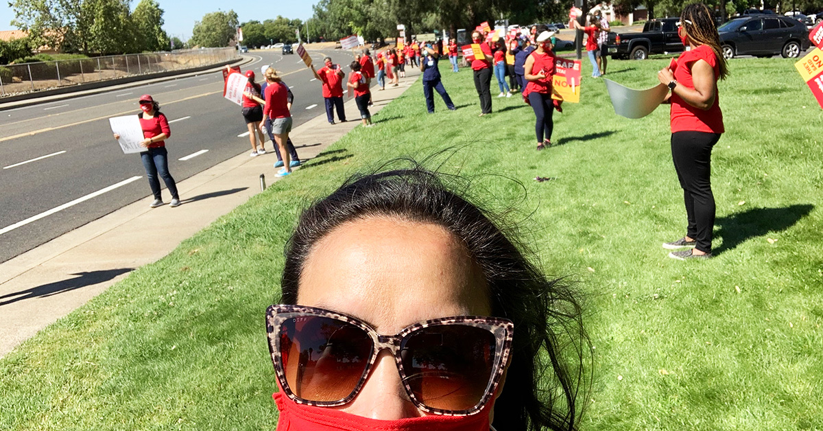 Nurses in a field by street, on strike