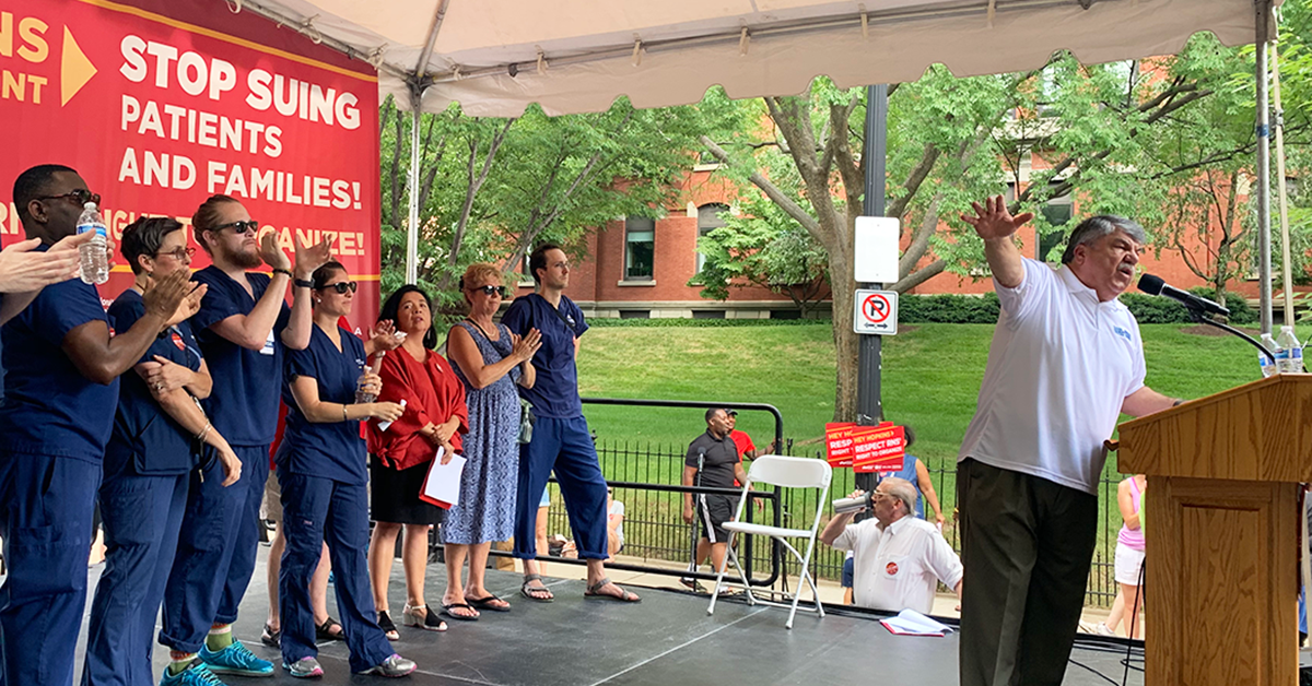 Richard Trumka speaking at outdoor podium in front of nurses