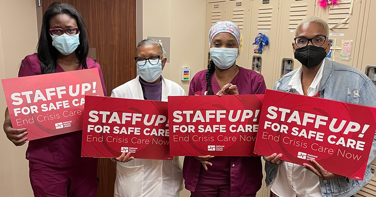 Four nurses inside hospital hold signs "Staff Up for Safe Patient Care"