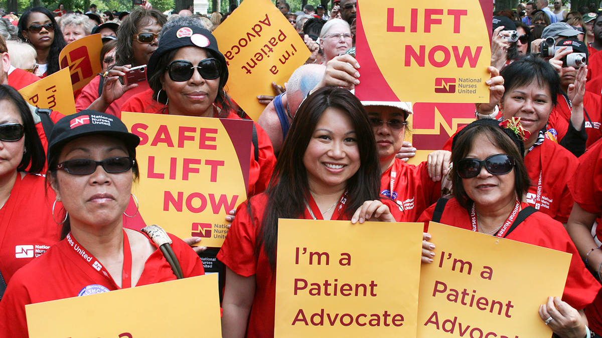 Nurses holding signs "Safe Lifgt Now" and "I'm a Patient Advocate"