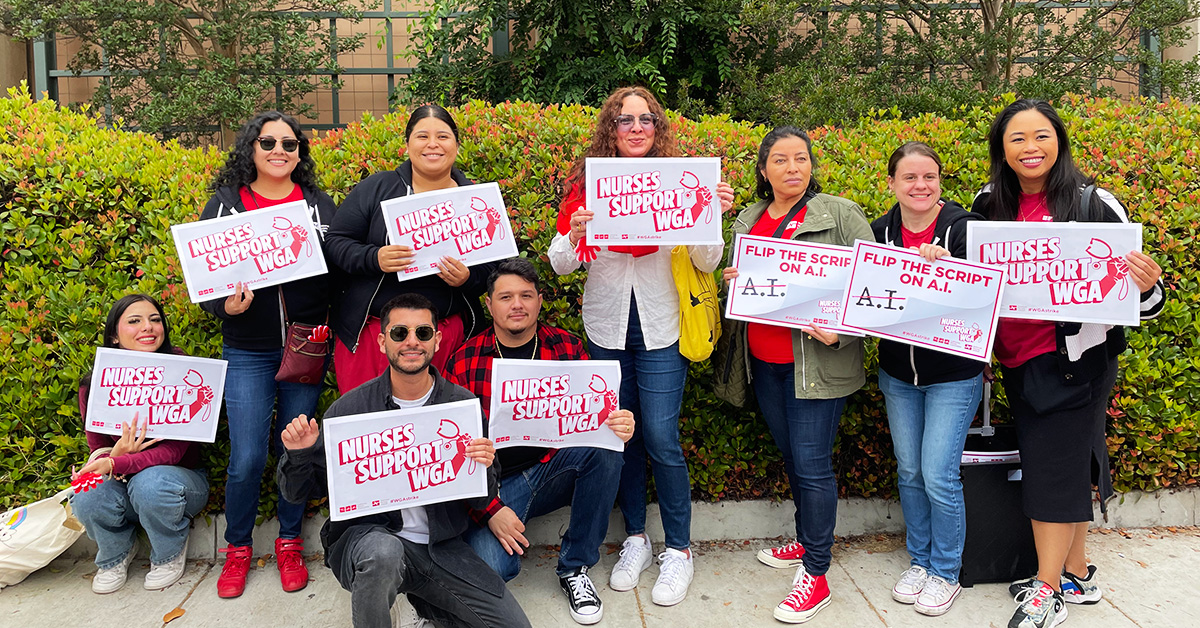 Group of nurses outside holding signs "Nurses Support WGA"