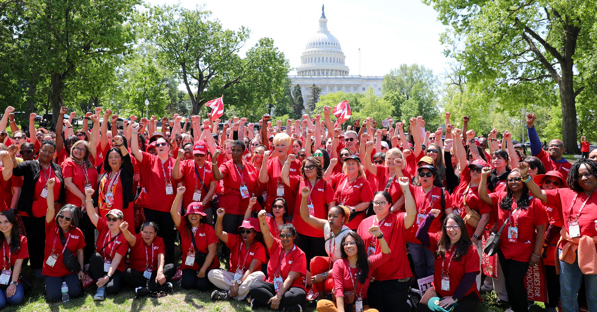 Large group of nurses in front of Capitol Building in Washington, D.C., smiling, with raised fists