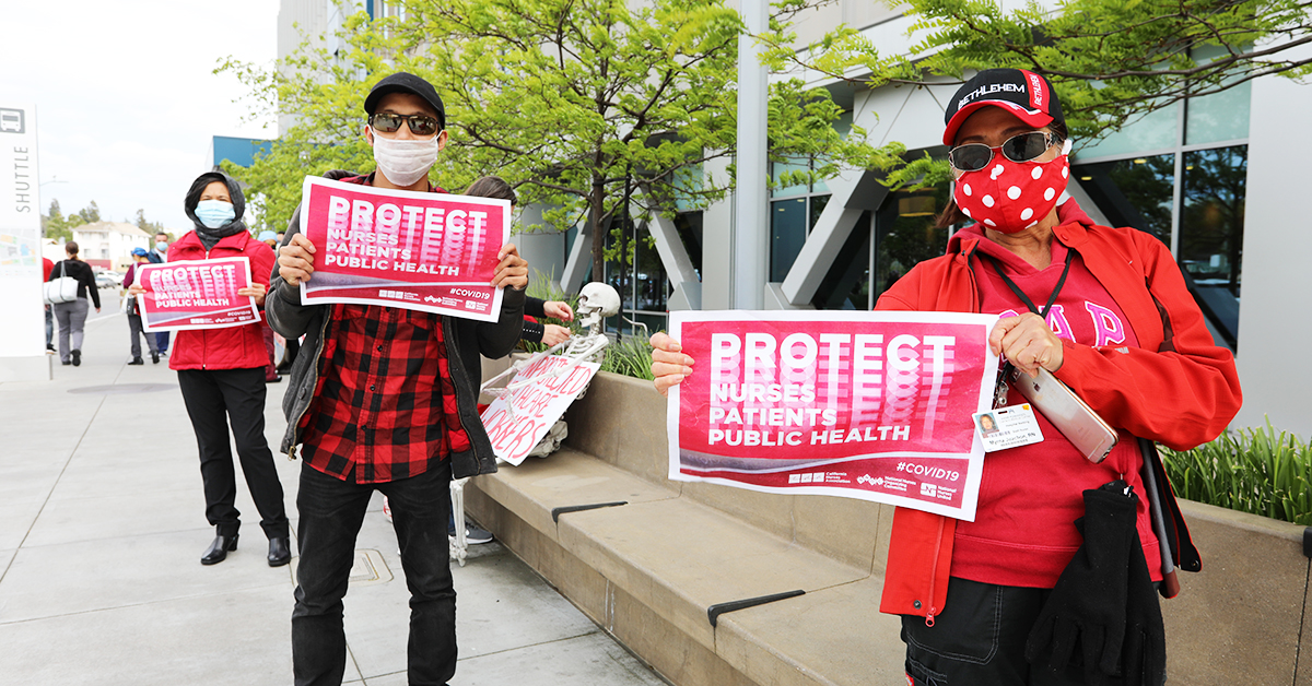 Nurses holding signs "Protect Nurses, Patients, Public Health"