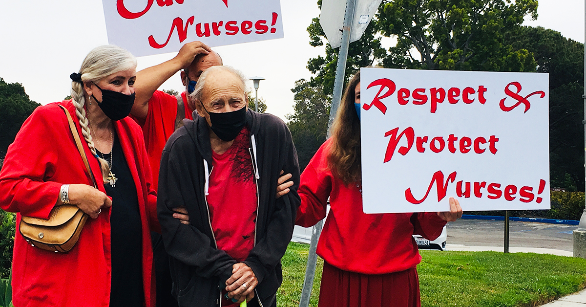 Community holding signs at rally "Respect & Protect Nurses!"