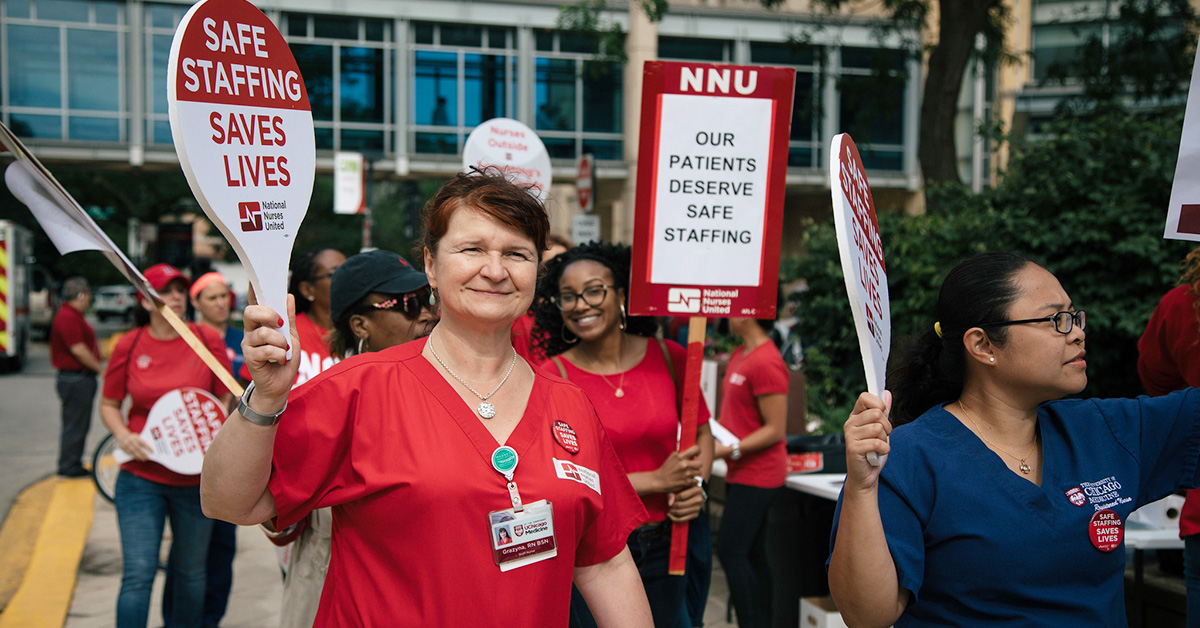 Nurses picketing outside hospital holding signs calling for safe staffing