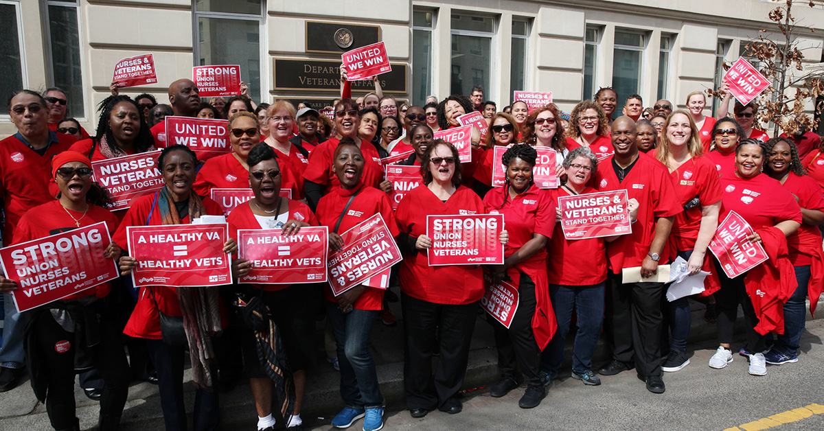 Group of nurses holding signs "Strong Union = Strong VA"