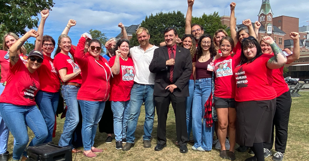 Nurses standing with Troy Jackson and Graham Platner, raised fists