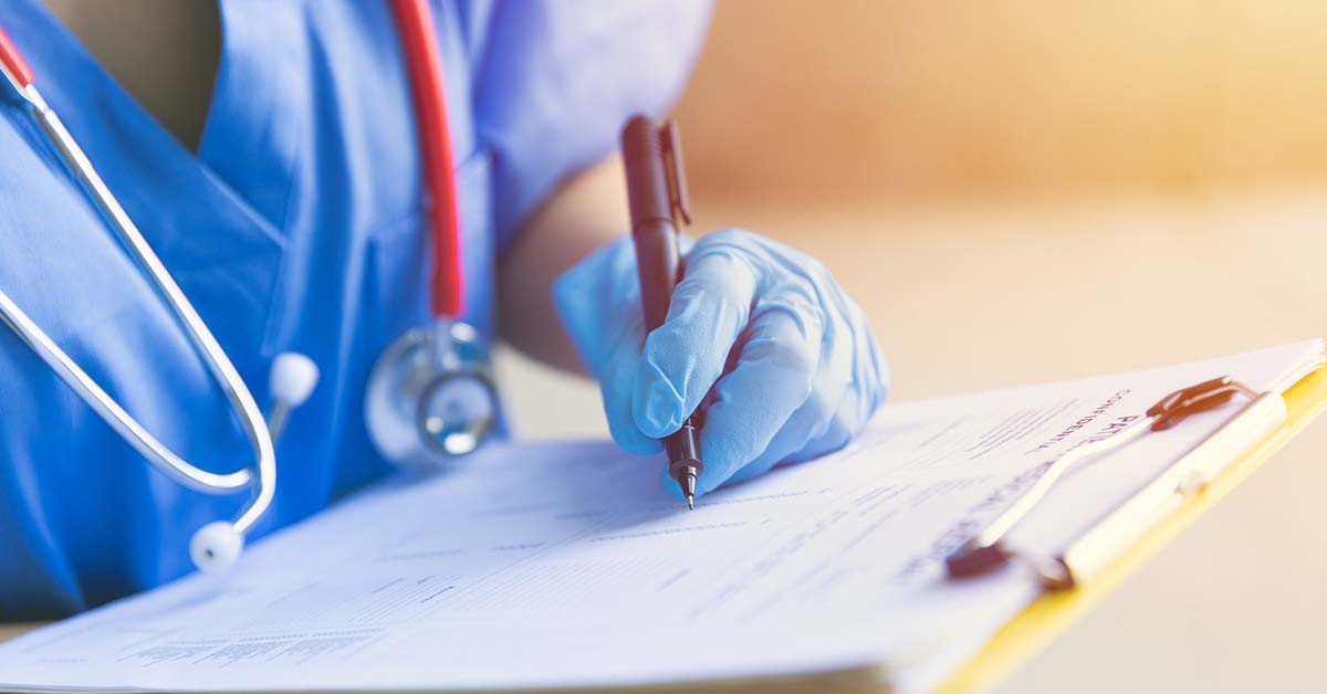 Nurse with clipboard signing document