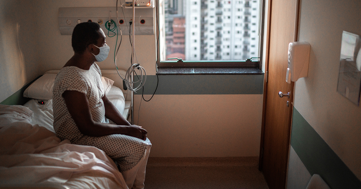 Patient of color looking out of hospital window 