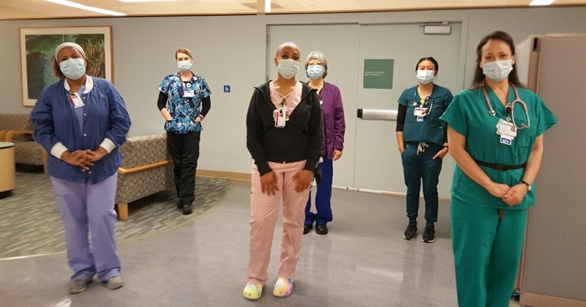 Group of six masked nurses inside hospital