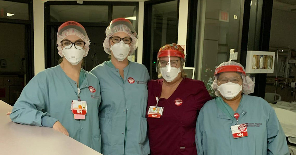 Group of four nurses inside hospital wearing masks