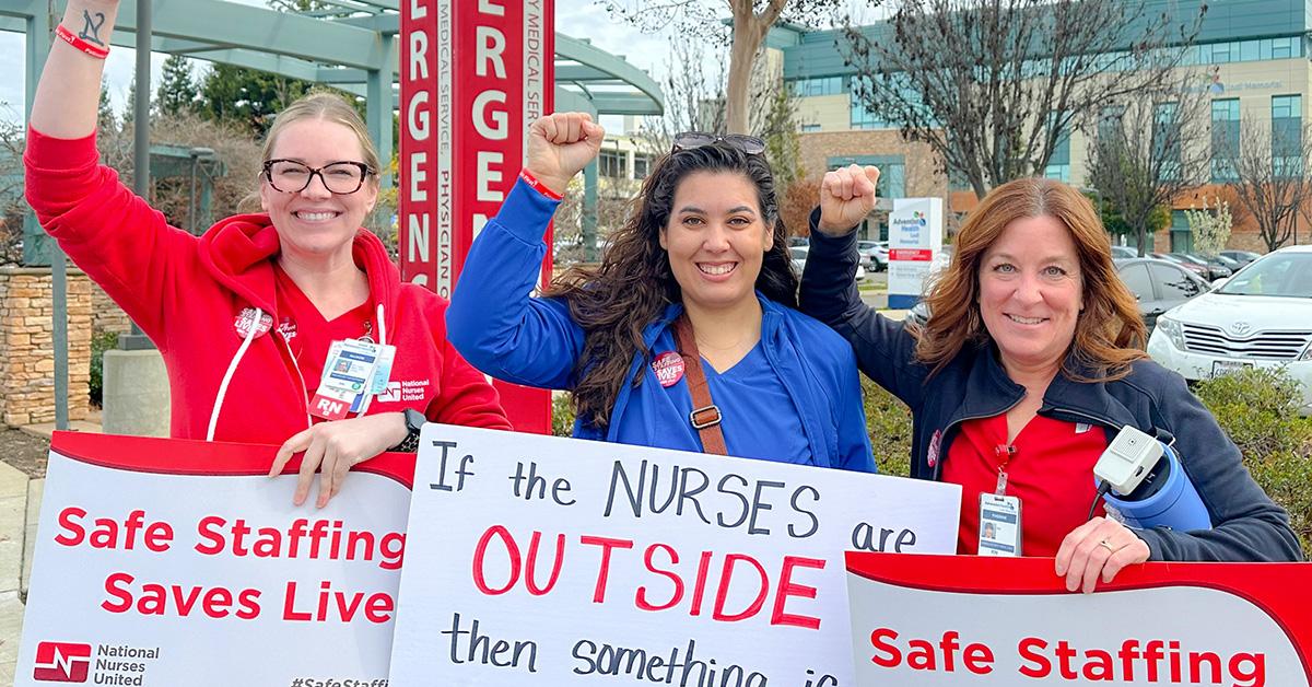 AHLM nurses picket holding signs with fists raised.