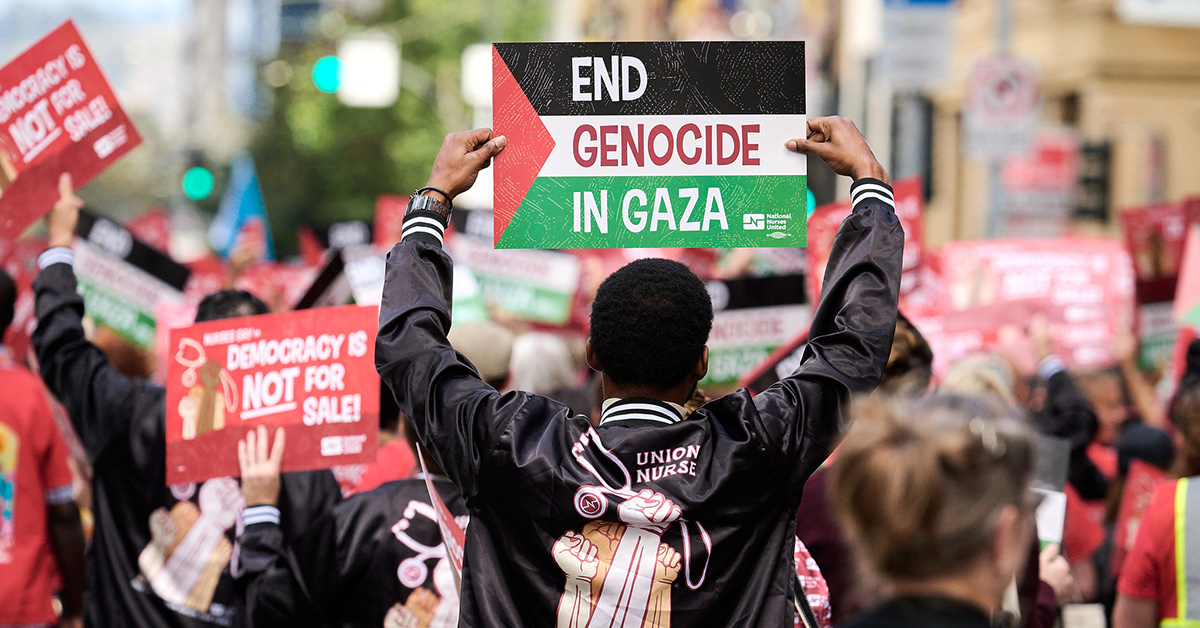 Nurse marching with sign "End Genocide in Gaza"