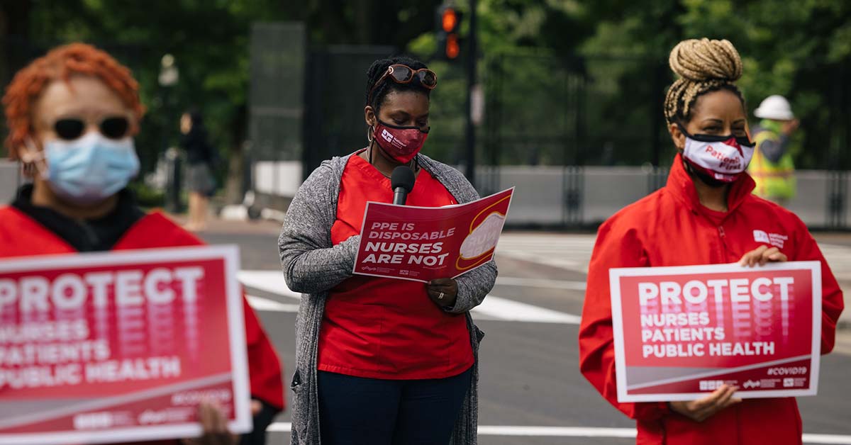 Masked nurses outside holds signs "Protect Nurses, Patients, Public Health"