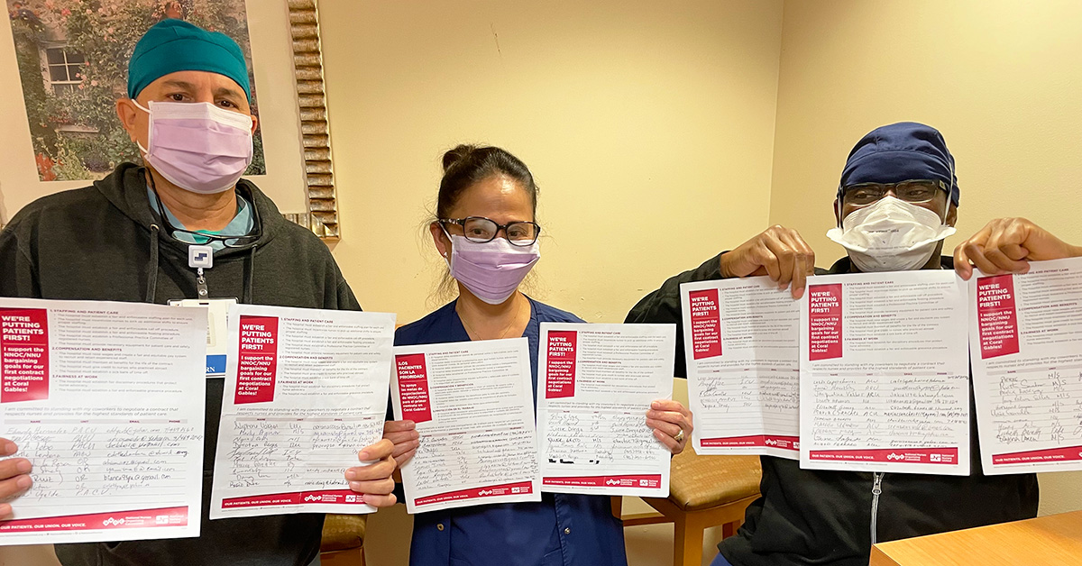 Three nurses inside hospital hold papers with signatures