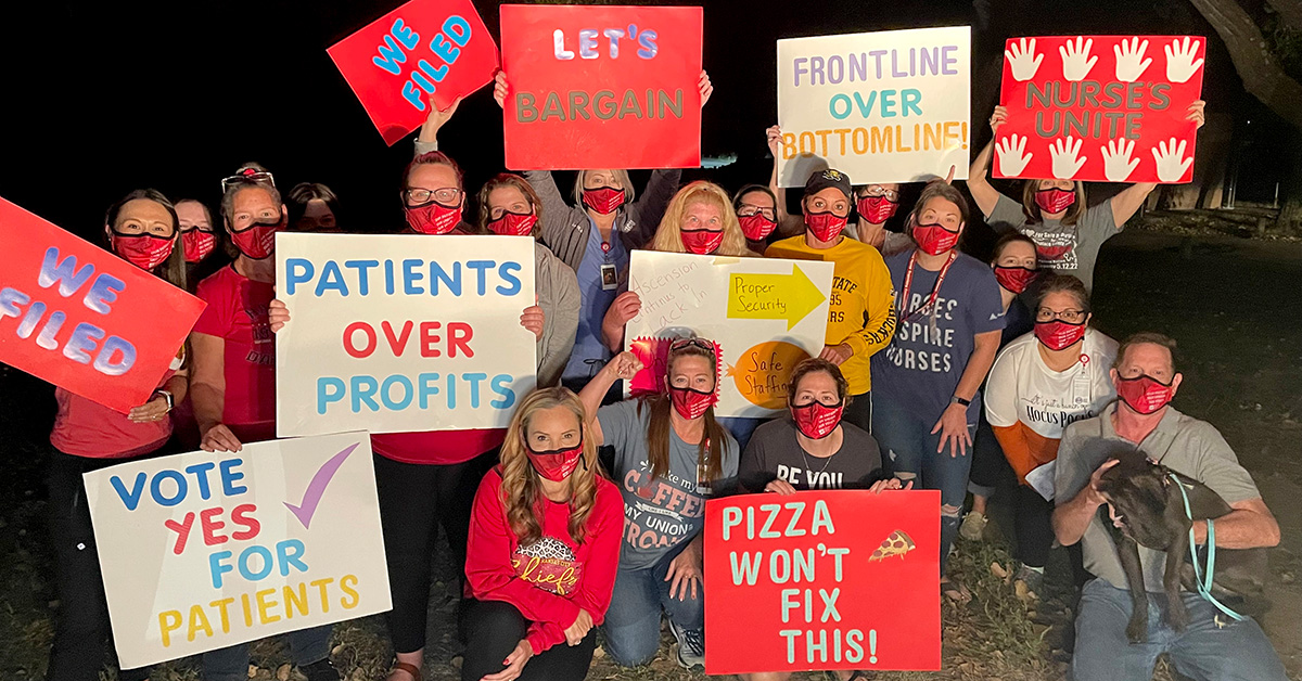 Group of nurses outside holding signs showing enthusiasm for organizing