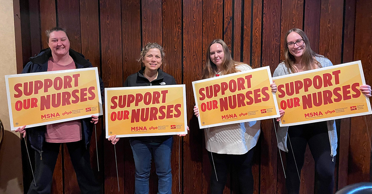 Four nurses inside holding signs "Support Our Nurses"