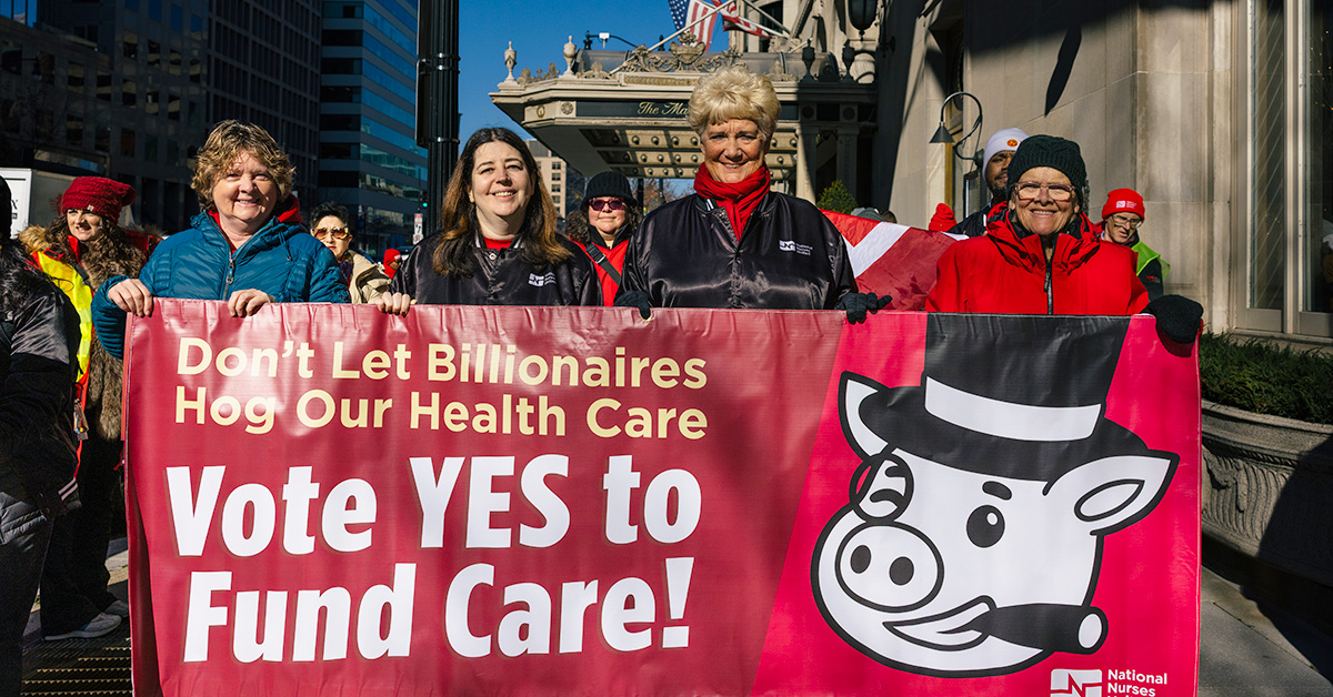 Four nurses outside holding banner "Vote YES to Fund Care"