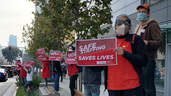 Nurses hold signs calling for safe staffing