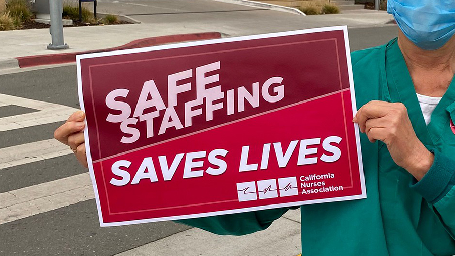 Nurse holds signs "Safe Staffing Saves Lives"