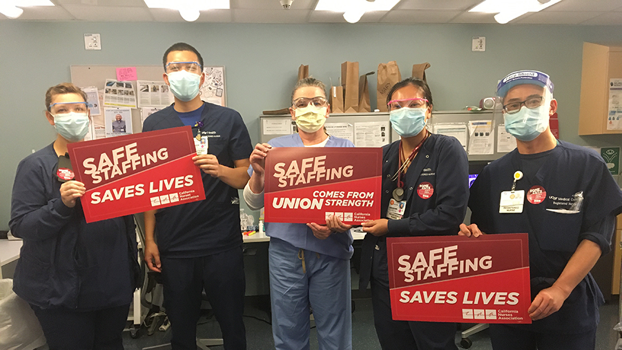 Nurses hold signs calling for safe staffing