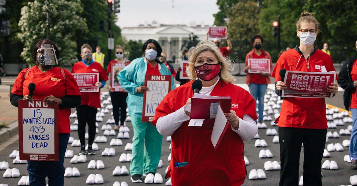 Nurses outside The White House hold signs "Protect Nurses, Patients, Public Health"