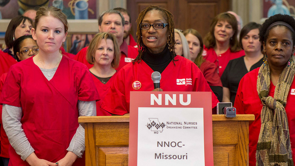 Group of nurses stand in front of podium with sign that says NNU NNOC Missouri