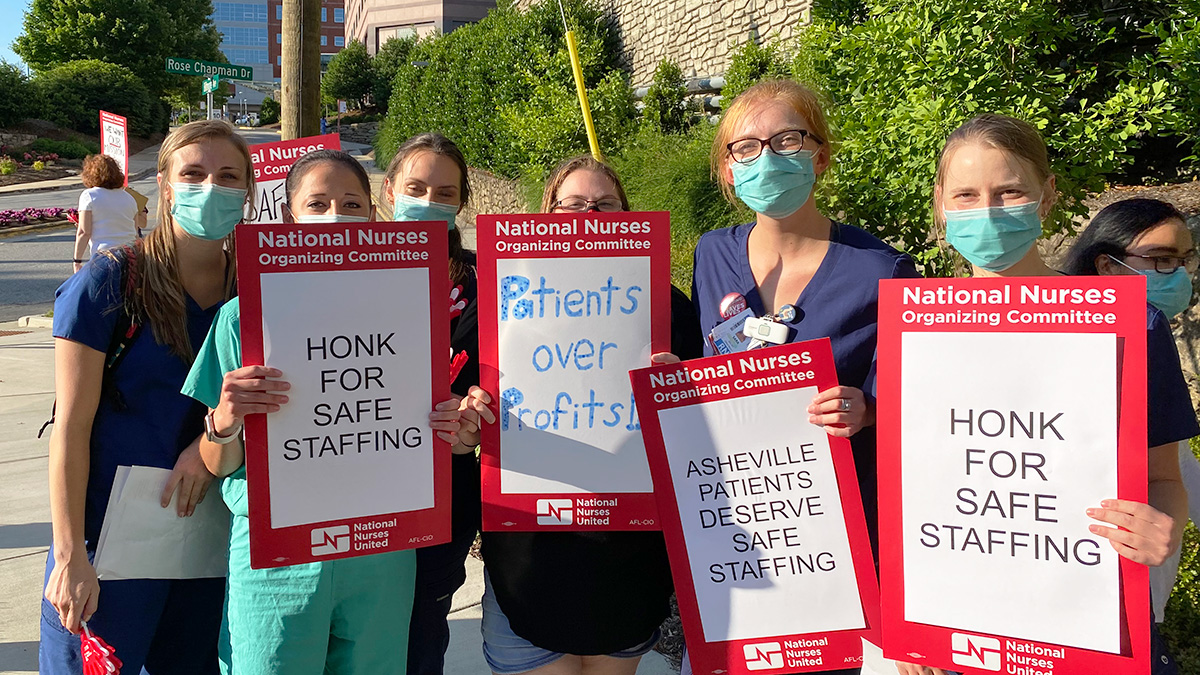 Group of nurses outside holding signs calling for patient protections