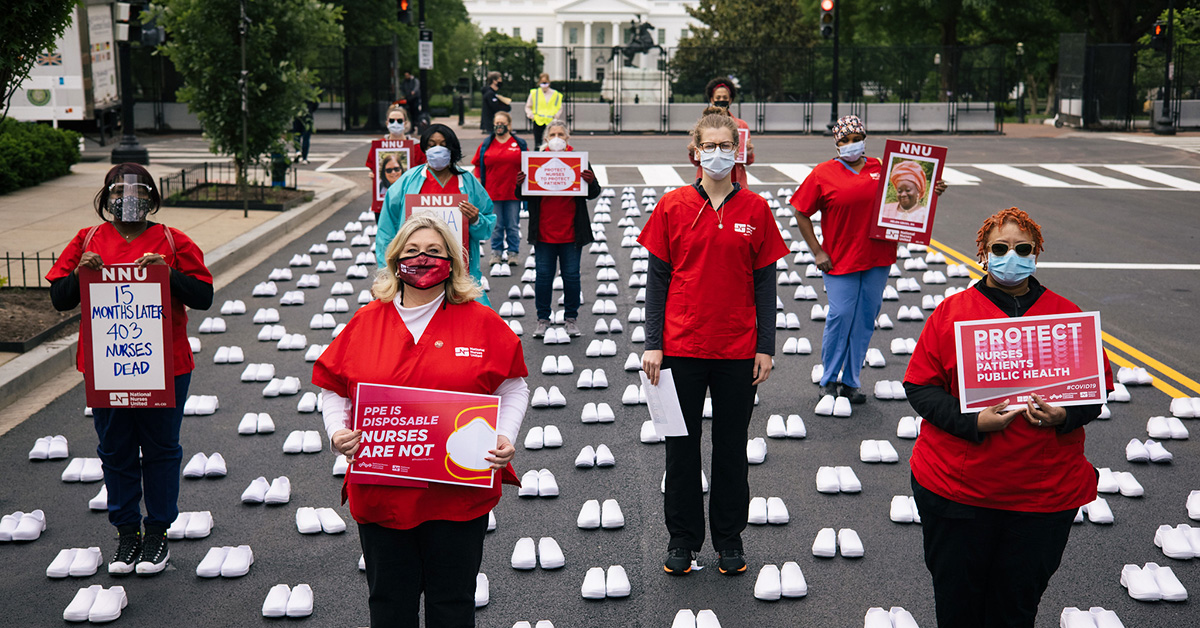 Group of nurses outside of The Whitehouse hold signs calling for permanent protection Covid measures