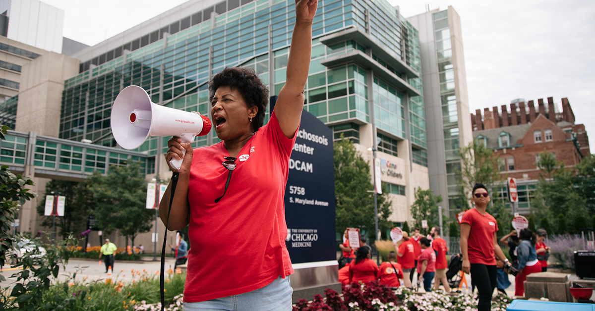 Nurse speaking through bullhorn with arm raised