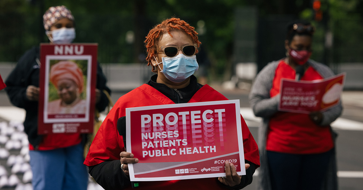 Masked nurse outside holds signs "Protect Nurses, Patients, Public Health"