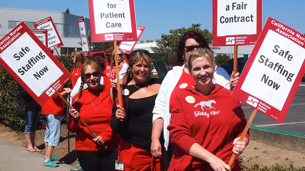 Nurses hold signs for safe staffing
