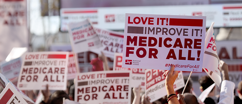 Nurse holding medicare for all sign